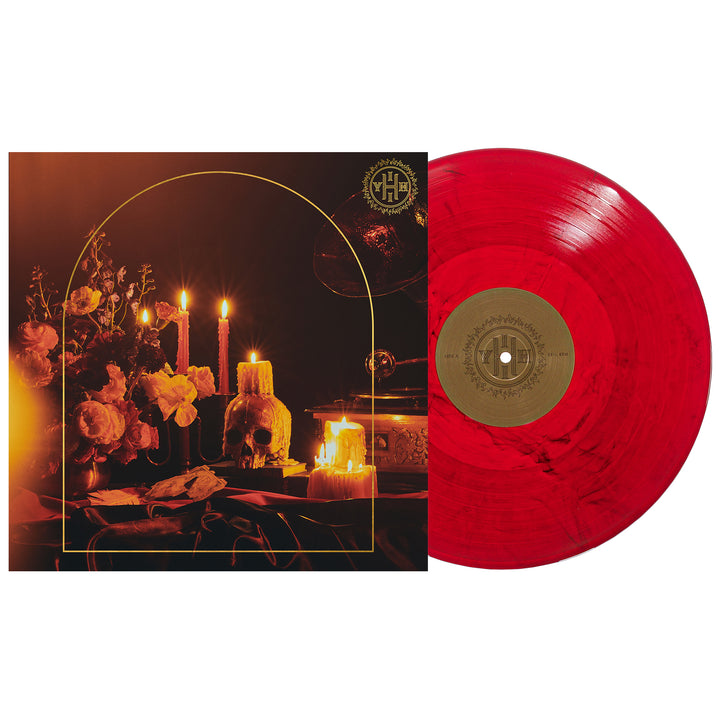 A red marbled vinyl record by Senses Fail rests near its album cover, which displays lit candles, flowers, and books on a dark table—capturing the moody vibe of Hell Is In Your Head.