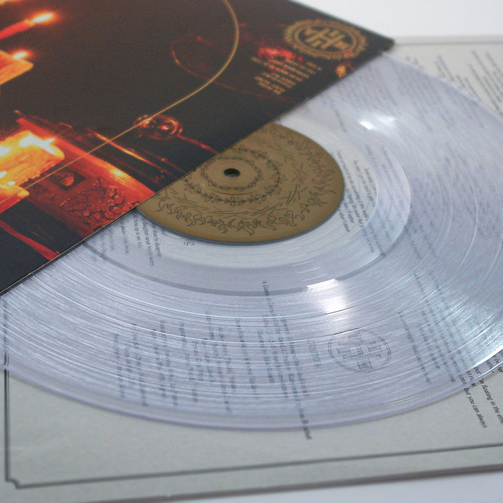 A clear vinyl record by Senses Fail, partially pulled from its sleeve to reveal gold and black label details—possibly featuring “The Burial of The Dead”—resting on an insert with printed lyrics or text.