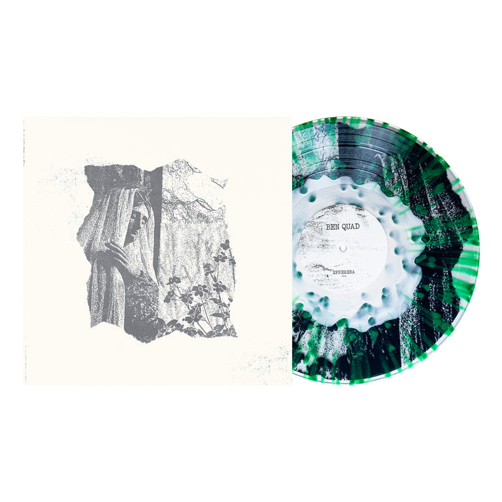 A marbled green, black, and white Ben Quad vinyl record is partially out of its sleeve. The sleeve has abstract grayscale art resembling a torn photo with textured natural elements; pressing info is included.