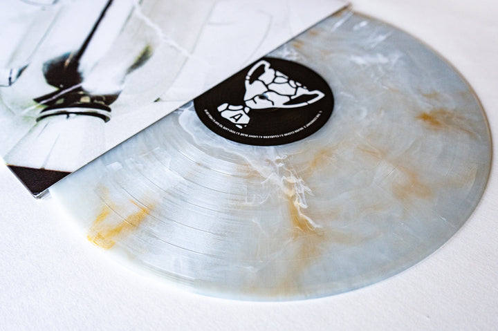 A marbled Golden Pearl Deluxe Marble Blend vinyl record by State Champs partially slides out of its sleeve, which features an abstract, minimalist design in white and black tones.