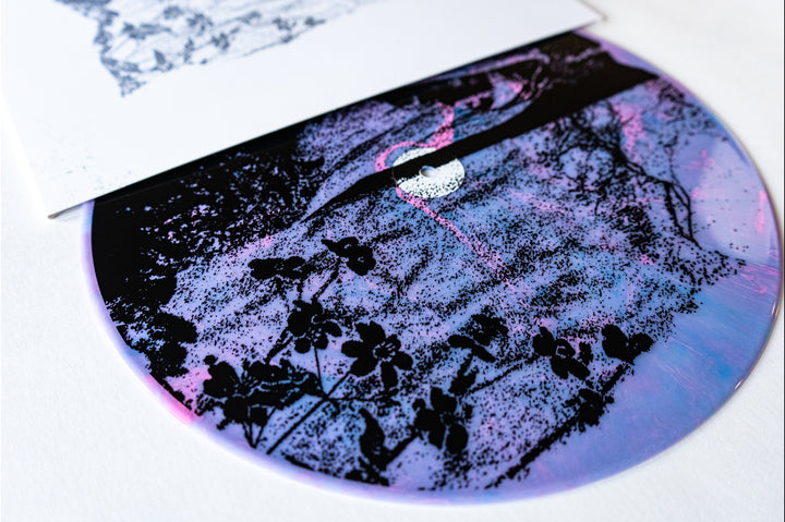 A close-up of Ben Quad’s limited edition vinyl, featuring a purple and blue marbled pattern with black florals and a white sleeve—available for vinyl presale before its October 25, 2024 release.
