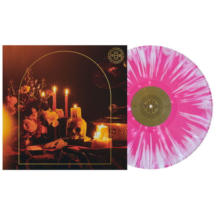A vinyl LP with a pink and white swirled design alongside an album cover featuring candles and floral elements in a dark setting.