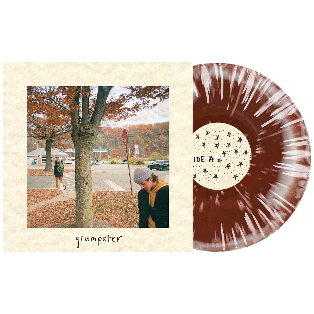 A Bone & Brown splatter Grumpster vinyl rests next to its album cover showing two people by an autumn tree, with “grumpster” below the image—a collector’s essential from Grumpster during the album presale.