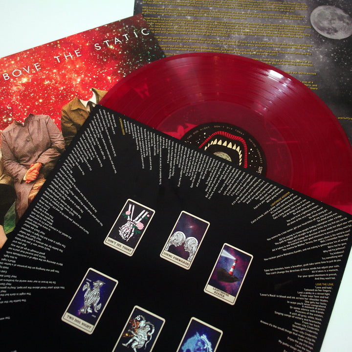 A vibrant red vinyl record by The Bar Stool Preachers rests on album art and an inner sleeve with tarot card illustrations, track list, and lyrics, all set against a starry Red Galaxy-inspired cover background.