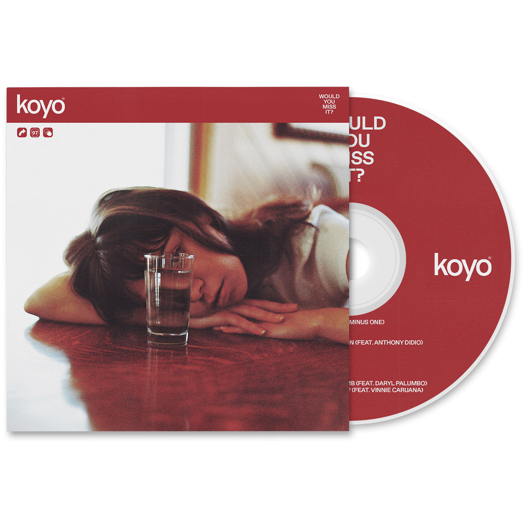 A KOYO Would You Miss It? CD with its cover, released in September 2023. The artwork features a person resting their head on a table beside a glass of water, highlighted by a bold red and white color scheme.