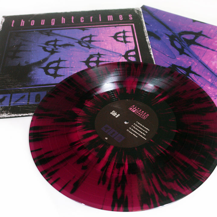 A maroon and black splatter Vinyl LP from thoughtcrimes is shown before its album cover, which features a hot pink on deep purple abstract design with the word thoughtcrimes at the top; the label displays text and track listings.