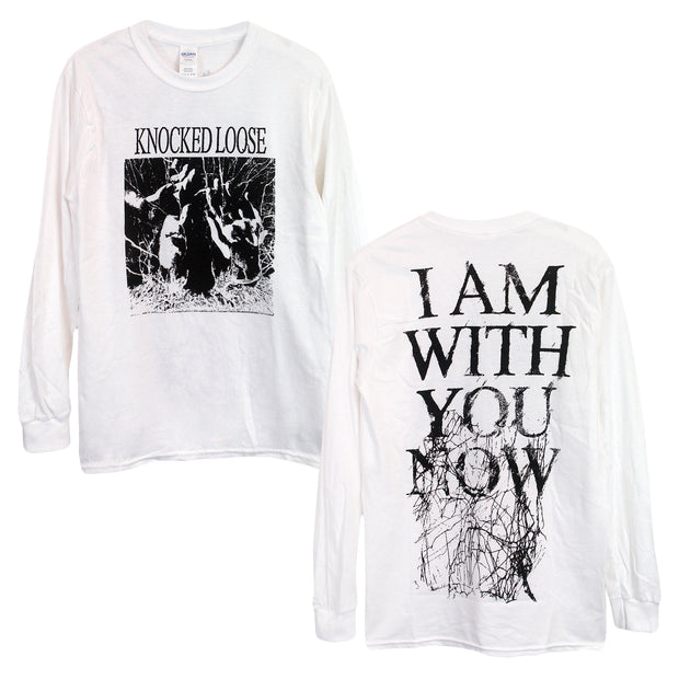 image of the front and back of a white long sleeve tee shirt on a white background. front of the long sleeve is on the left and has a full chest print in black. Knocked loose is written at the top and below that is an image of a persons face with sunglasses on and hands up with white scribbles surrounding it. The back of the long sleeve is on the right and has a full back print in black that says i am with you now and has black scribbles.