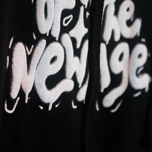 close up image of the white puff print on a black hoodie.