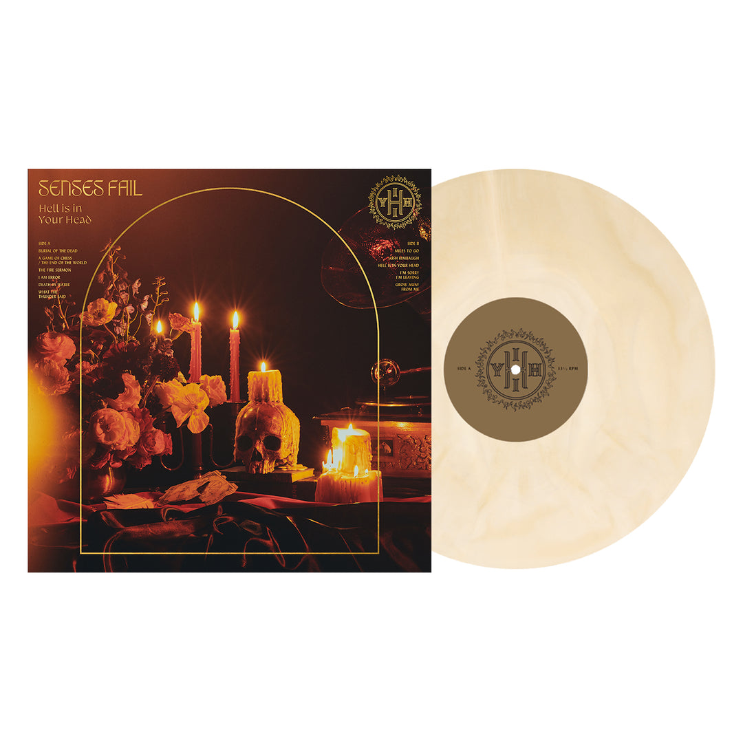 A Senses Fail Hell Is in Your Head vinyl in a gold & white galaxy swirl sits by its cover, which shows candles, flowers, and a skull on a dark table—perfectly capturing the albums moody vibe.