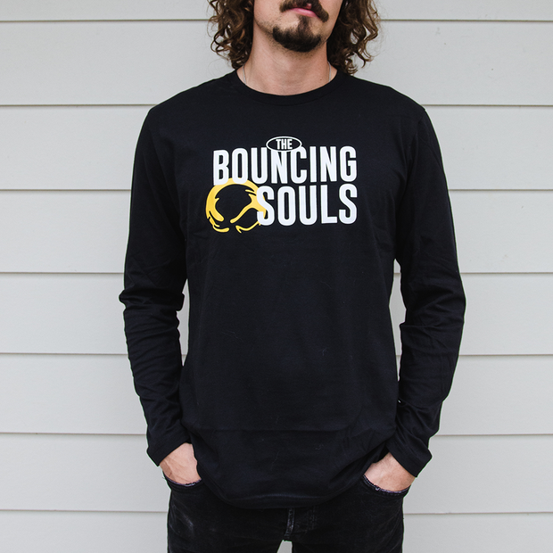 image of a man wearing a black long sleeve tee shirt. Front of Long Sleeve has "The Bouncing Souls" text in white in the center chest, with the bouncing souls logo right next to it