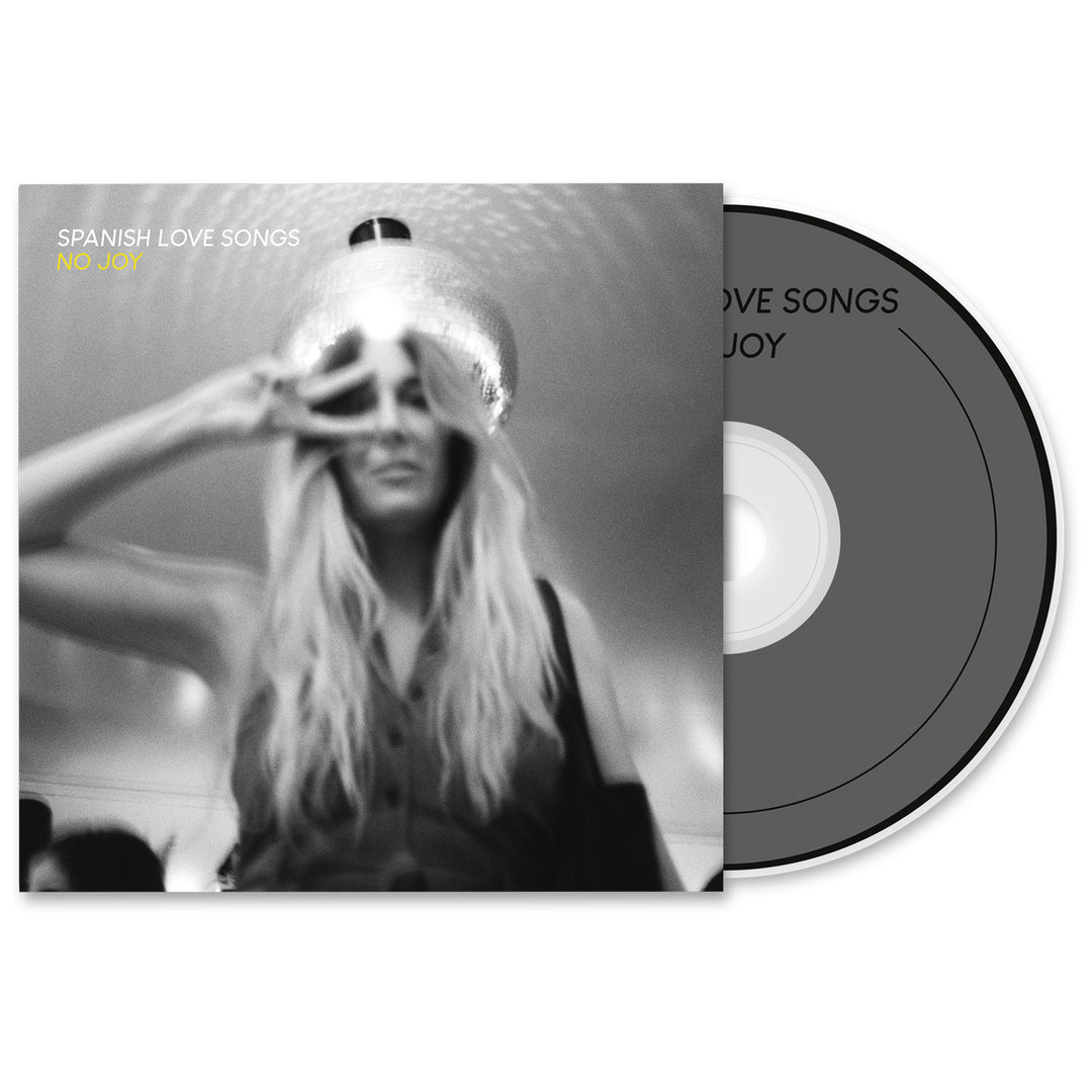 A CD and cover art for the Spanish Love Songs album No Joy, featuring a blurred black-and-white photo of a long-haired woman making a peace sign under a ceiling light. Packaging includes album release date details.