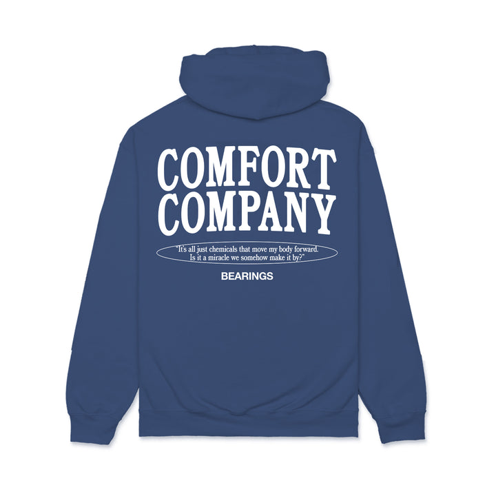 The Bearings blue hoodie, inspired by wheelchair accessories, features bold white COMFORT COMPANY text and a thoughtful quote on the back, evoking the comfort and everyday support of a blue cushion.