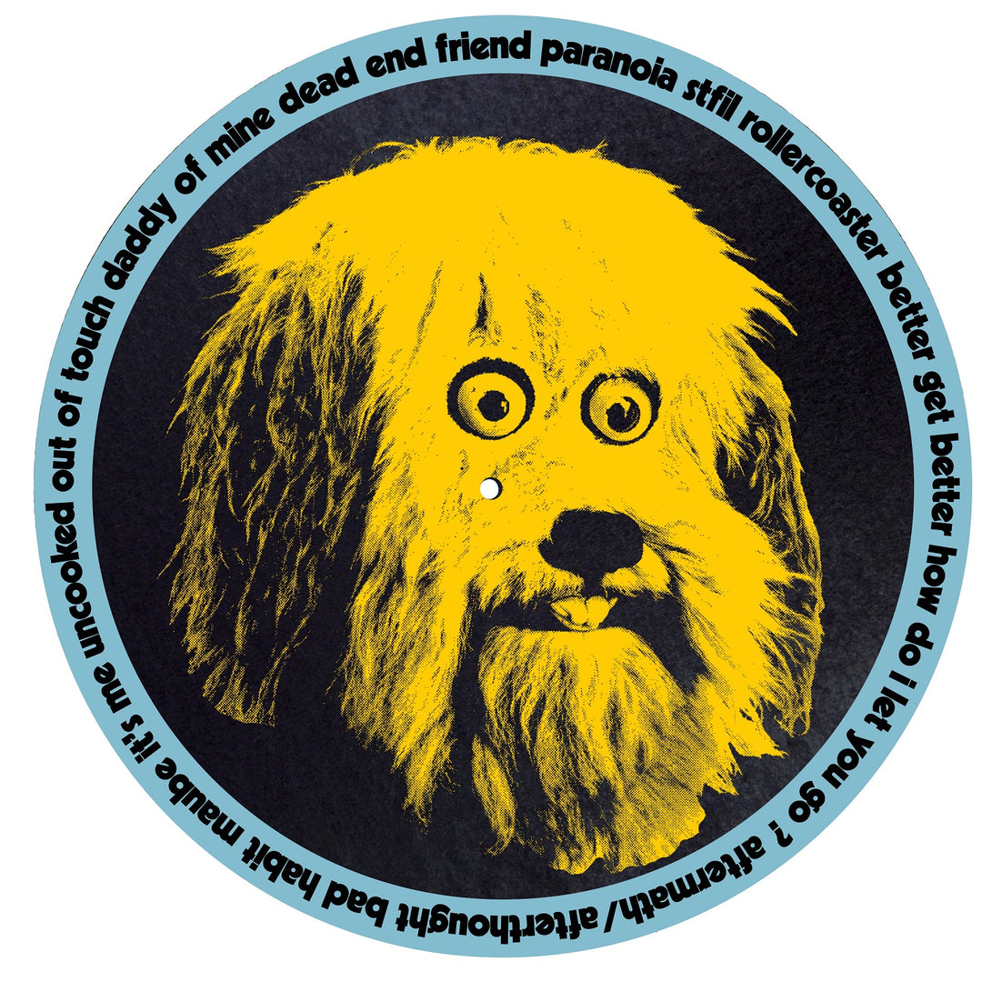 A round Four Year Strong slipmat features a yellow cartoon shaggy dog's face with googly eyes on black, and blue text circling the edge with phrases like dead end friend, rollercoaster, analysis paralysis, and bad habit.