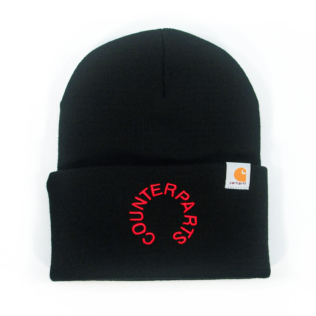 A black winter beanie with a folded brim featuring the Counterparts logo embroidered in red and a small rectangular Carhartt label on the cuff—ideal for metalcore fans.