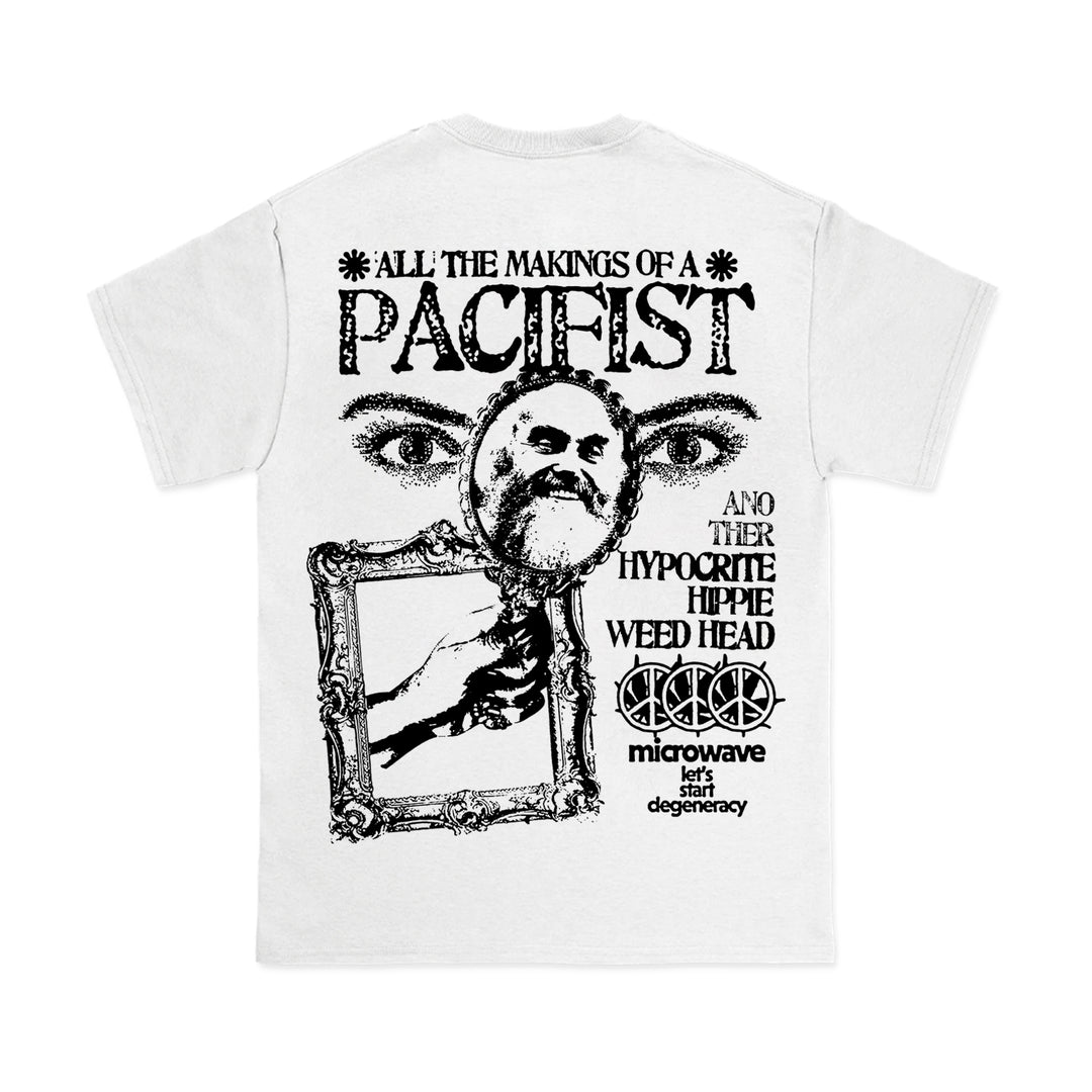 A Microwave brand white Comfort Colors T-shirt featuring black graphics of a pair of eyes, an angry man in a magnifying glass, a hand with a frame, and the text "All the makings of a pacifist and other hypocrite hippie weed head.