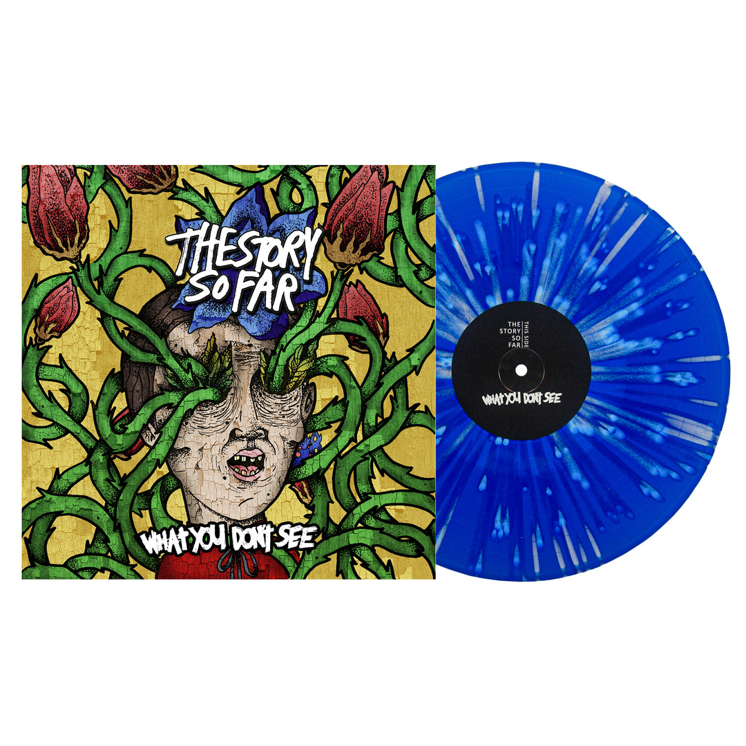 A royal blue vinyl record with white streaks sits by its album cover, displaying The Story So Far and the title "What You Don’t See" above art of a face enveloped in green vines and red flower buds.