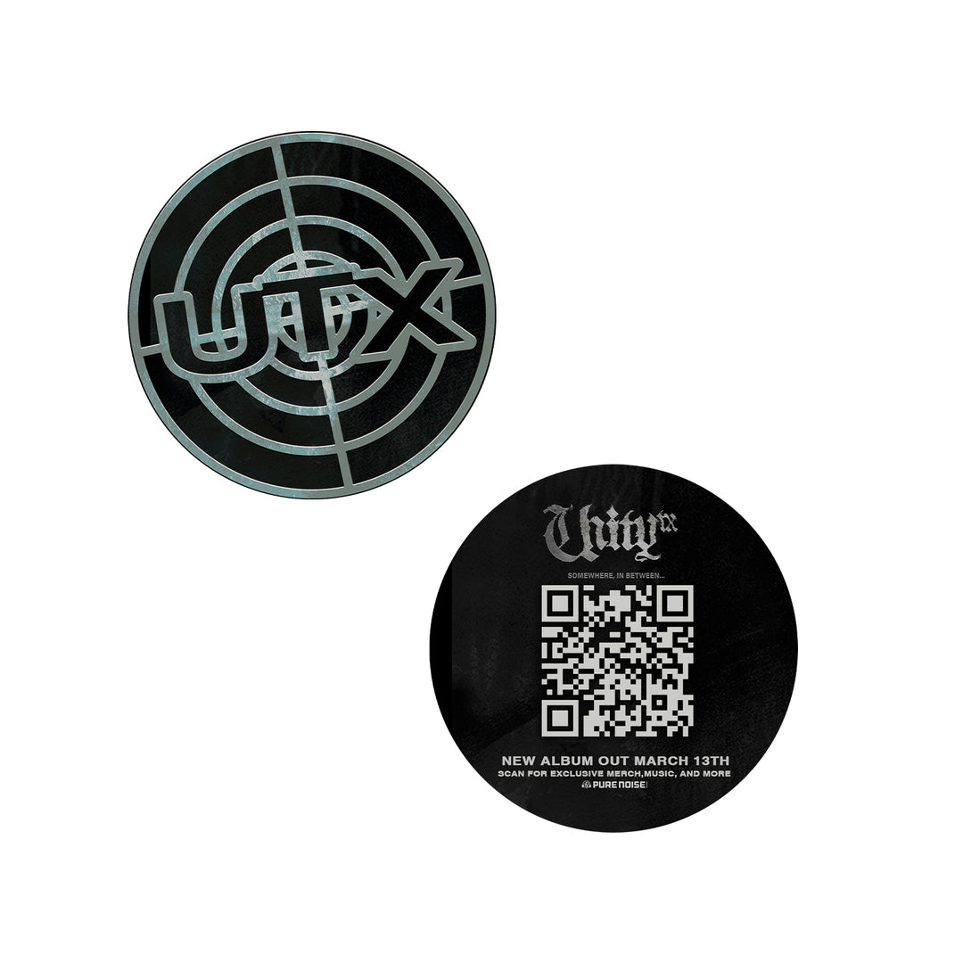 Two round black stickers: one features UNITYTX in a target-style design; the other shows Untrxx in gothic font above a QR code and text about their new album "Somewhere In Between," releasing March 13th.