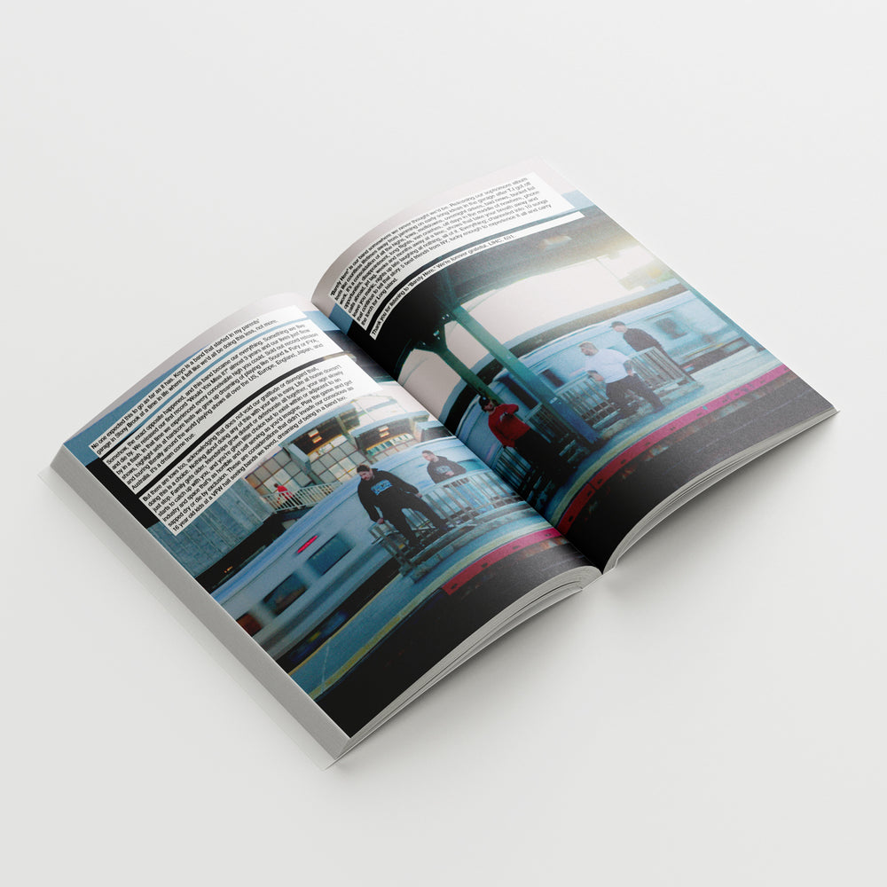 An open KOYO photo book rests on a white surface, displaying two pages of tour photography with people standing on a train platform beside a train, accompanied by blocks of text above the images.