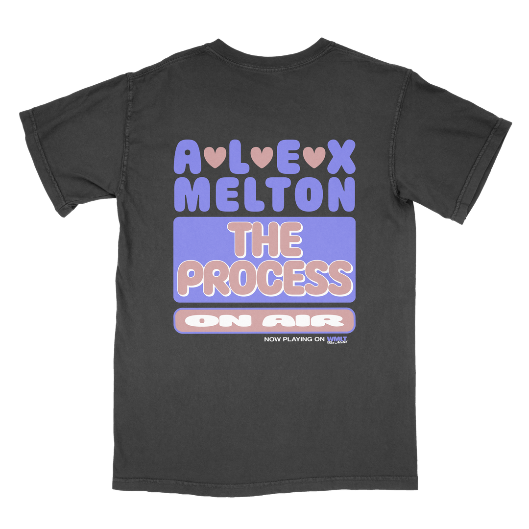 A black Alex Melton Heavy t-shirt with colorful, retro text: “ALEX MELTON THE PROCESS ON AIR,” hearts above “ALEX,” and “NOW PLAYING ON YOUTUBE” in small text at the bottom.