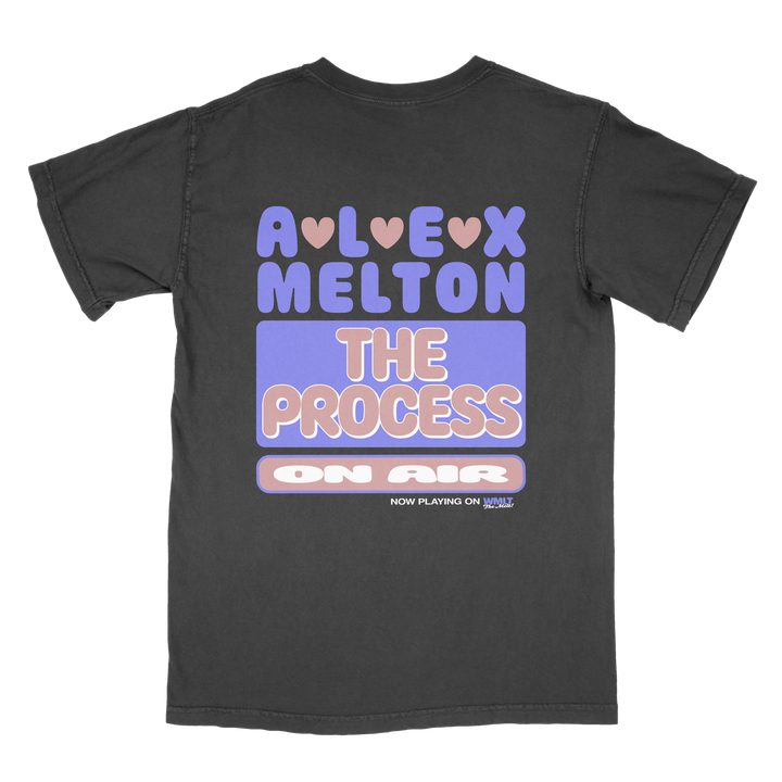 A black Alex Melton Heavy t-shirt with colorful, retro text: “ALEX MELTON THE PROCESS ON AIR,” hearts above “ALEX,” and “NOW PLAYING ON YOUTUBE” in small text at the bottom.