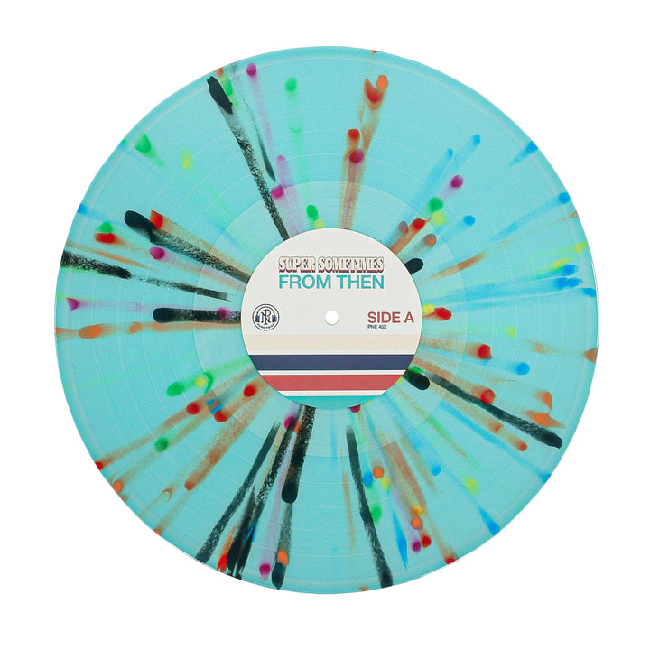A light blue vinyl record by Super Sometimes with rainbow splatter radiating from the center. The label says SUPER SOMETIMES FROM THEN & NOW SIDE A, with red, blue, and beige stripes underneath.