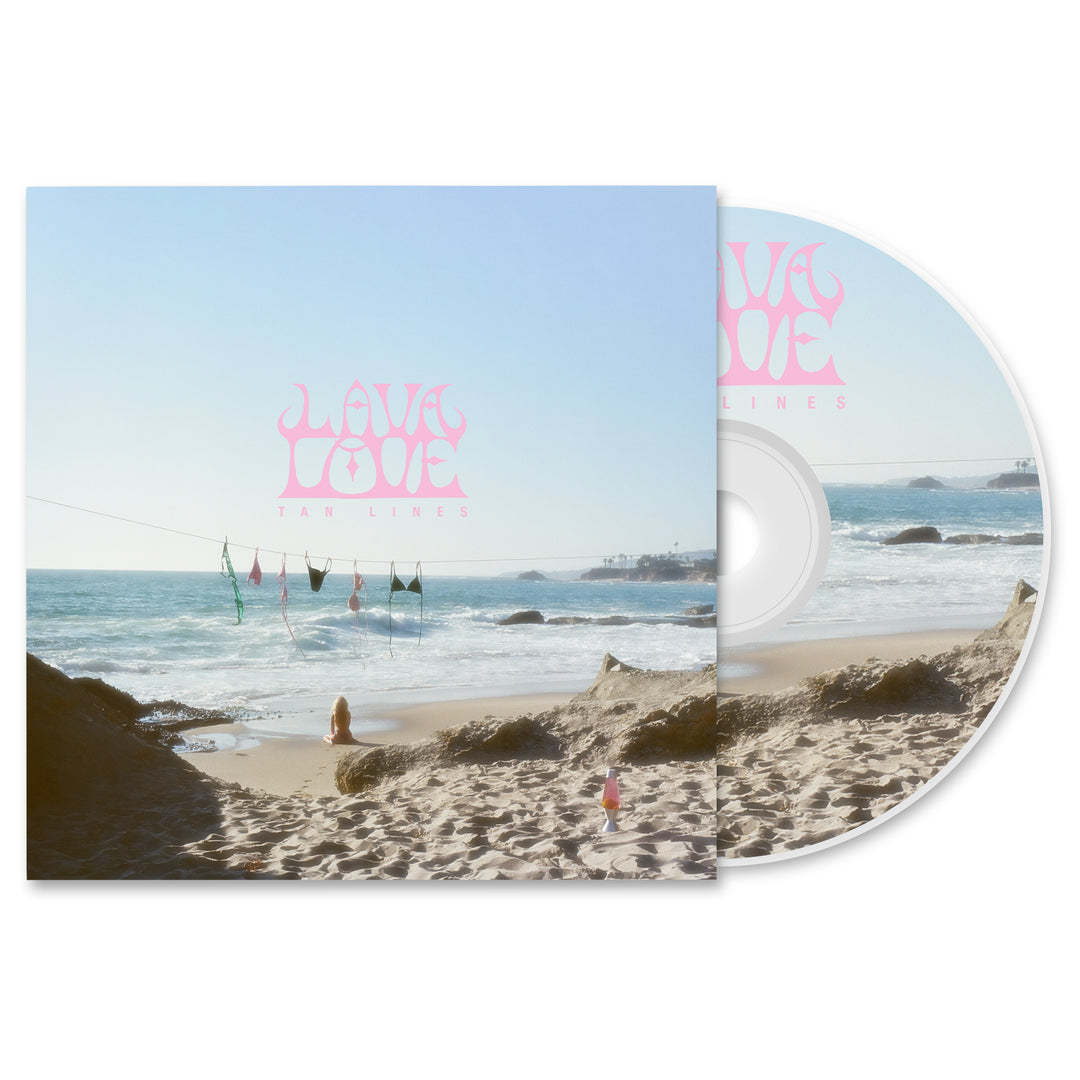 LAVALOVE Tan Lines CD and case with a beach-themed album cover—clothes on a line, person on sand, waves, rocks, blue sky. Pink “LAVA LOVE TAN LINES” text. Great for any presale or music bundle.