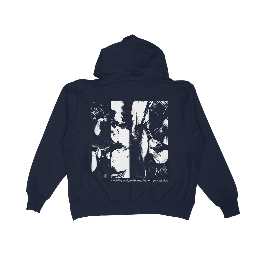The KOYO black hoodie features a bold, abstract black-and-white graphic on the back and text below that reads, "watch The World Navy outside go by from your window.