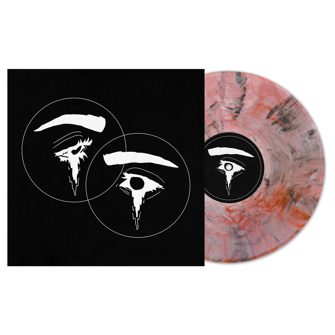A limited edition Seahaven vinyl in Amber Deluxe Marble (pink, gray, and white) is partially shown beside its black album cover, which displays two abstract white eyes and eyebrows inside overlapping circles.