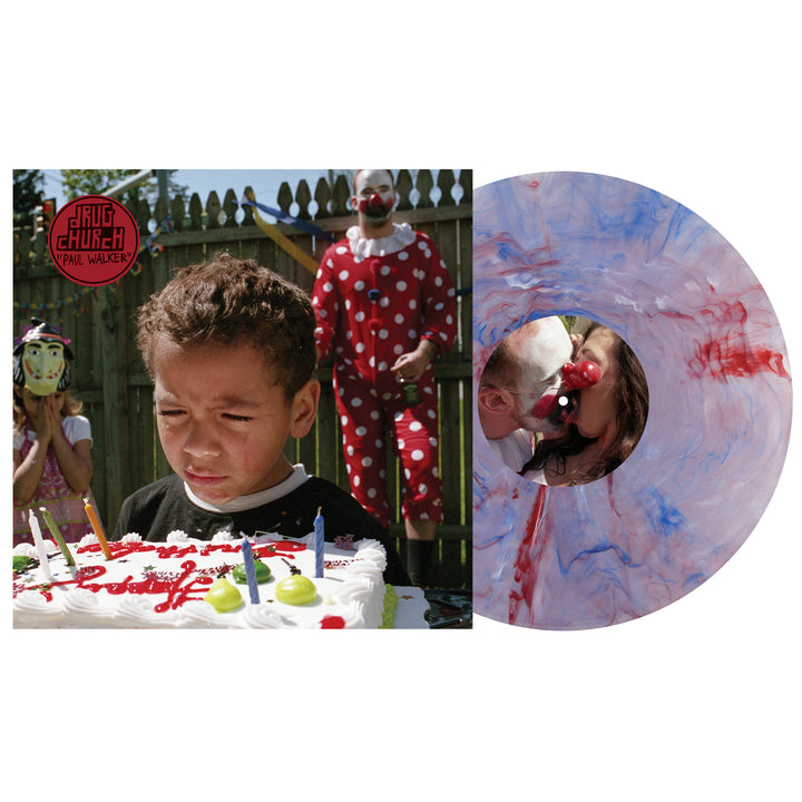 A young boy stands upset before a candlelit cake, with two clowns behind him. Next to the scene is a blue and pink marble vinyl LP from Drug Church—a unique offering for this album presale.