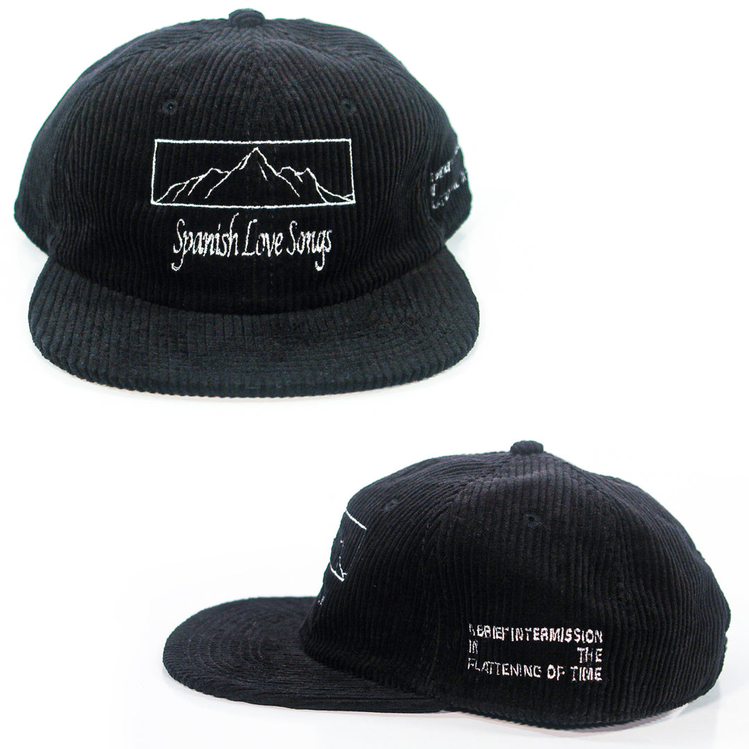 A black cord cap from Spanish Love Songs with white embroidery. Features a mountain outline and "Spanish Love Songs" text on the front, and "A brief intermission in the flatline of time" on the side. Shown from two angles.
