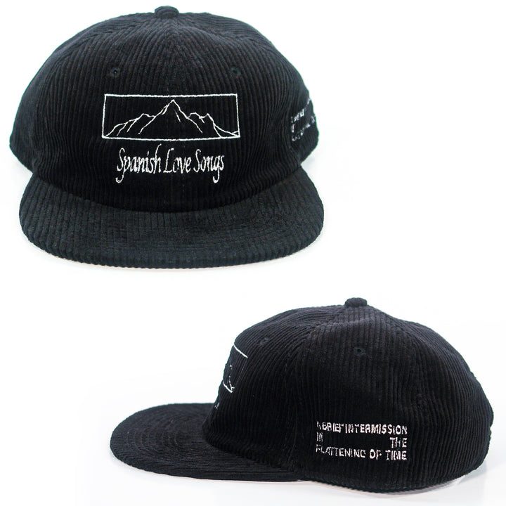 A black cord cap from Spanish Love Songs with white embroidery. Features a mountain outline and "Spanish Love Songs" text on the front, and "A brief intermission in the flatline of time" on the side. Shown from two angles.