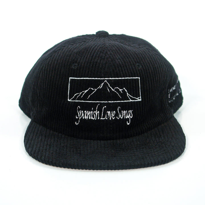 A black cord cap by Spanish Love Songs, featuring white embroidered mountain outlines and "Spanish Love Songs" text on the front.