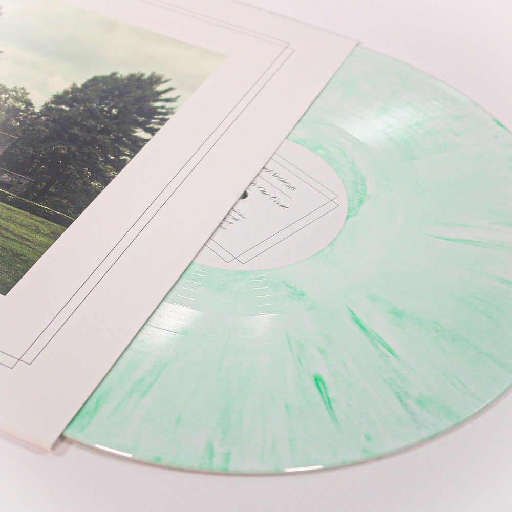A mint green marbled Green Apple Cream Blend Vinyl record by Cloud Nothings slides out of a white sleeve featuring trees and grass. Ideal for collectors seeking exclusive presale editions.