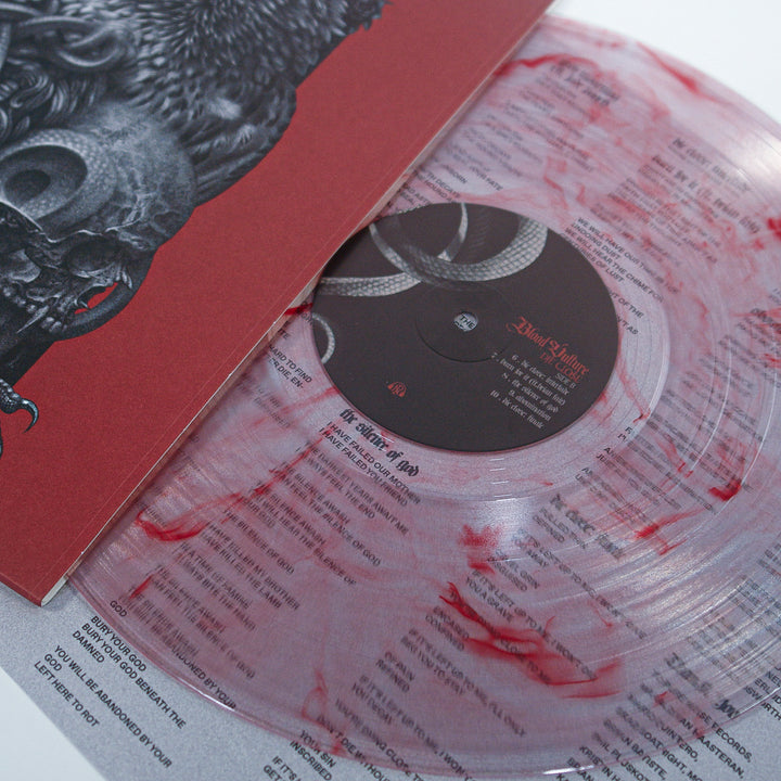 A transparent vinyl record with red splatter Bloodshot Marble detail, showing the tracklist for Blood Cults The Silence of God and part of its illustrated album cover.