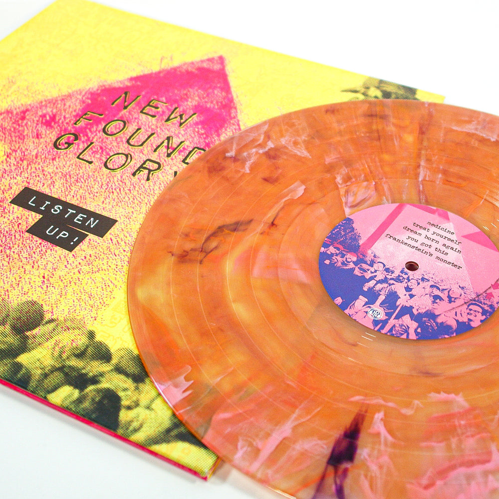 New Found Glory’s Tropical Sunset Deluxe Marble Vinyl features a vibrant marbled orange-and-yellow design next to its bold album cover with a pink arrow on yellow. 