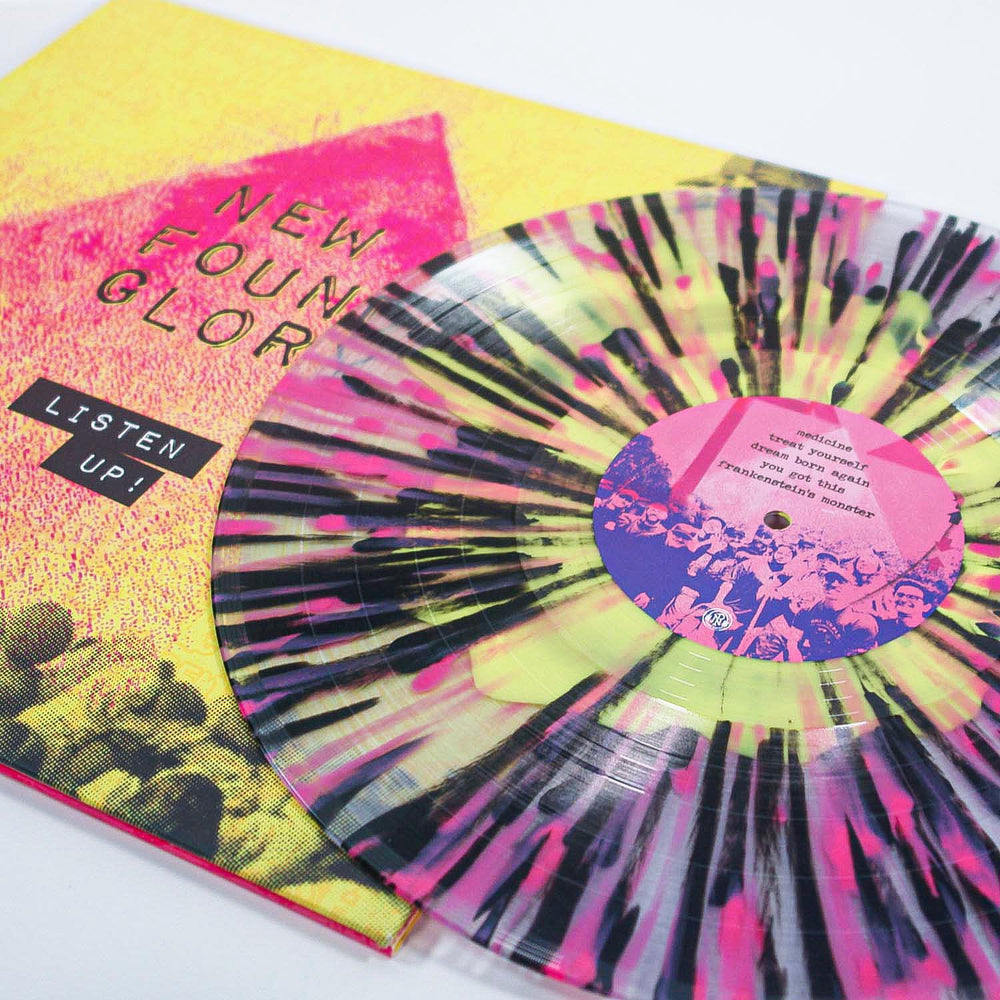 A black and pink splatter vinyl LP sits next to a yellow album cover with a pink arrow and "New Found Glory - Listen Up!"