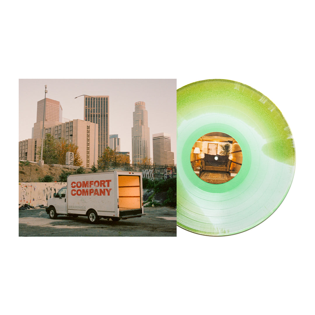 A green Bearings vinyl record, possibly glitter LP, partially covers an album cover with their moving truck at sunset. The center label shows a cozy living room—ideal for fans waiting for the Bearings album presale.