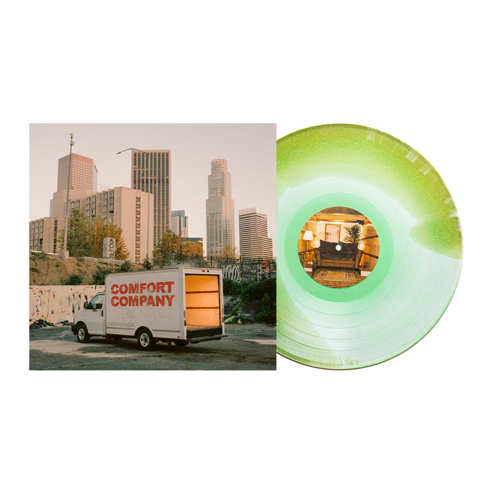 A green Bearings vinyl record, possibly glitter LP, partially covers an album cover with their moving truck at sunset. The center label shows a cozy living room—ideal for fans waiting for the Bearings album presale.