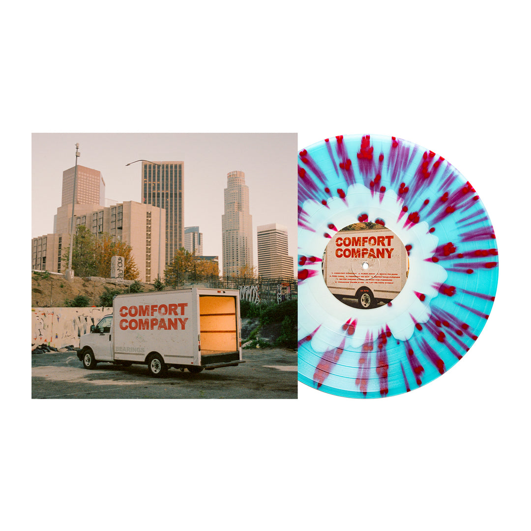 A Bearings Electric Blue Vinyl LP with blue, white, and red splatter rests next to an album cover showing a Comfort Company truck in front of tall city buildings beneath a clear sky.