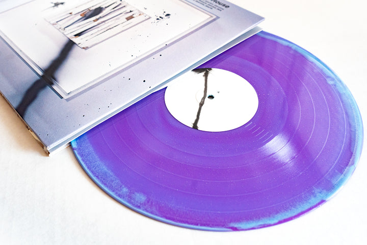 A purple Glitter Vinyl LP by Spite House, partially pulled from a minimalist matching cover, rests on a white surface. The record has a white center label with a simple black line design. Album releases September 16th, 2025.