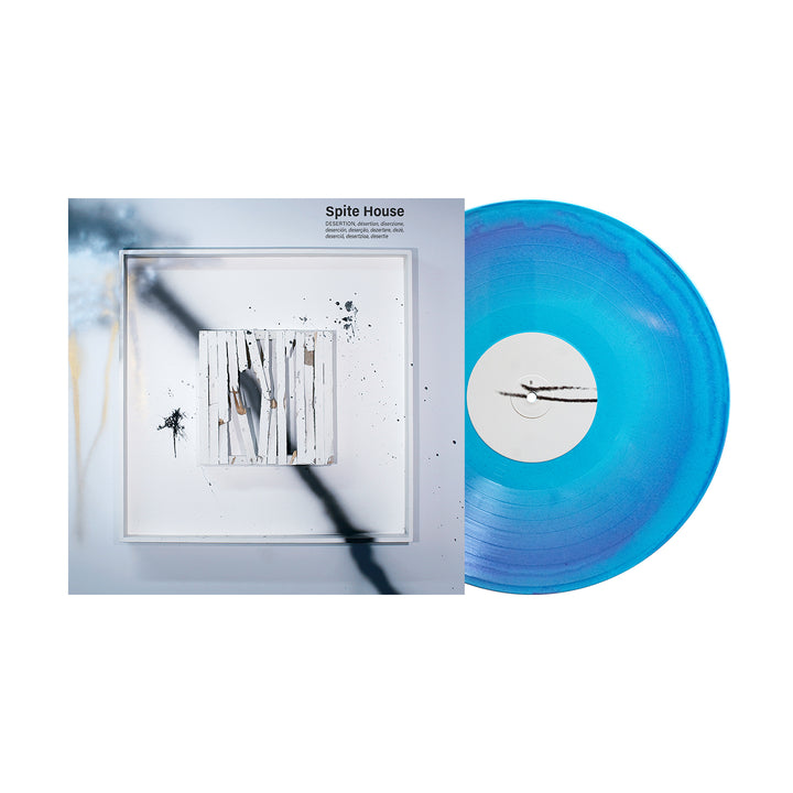 A blue Glitter Vinyl LP by Spite House rests next to its album cover, featuring abstract black and white painted sticks on a pale background. The album "Spite House" releases on September 16th, 2025.