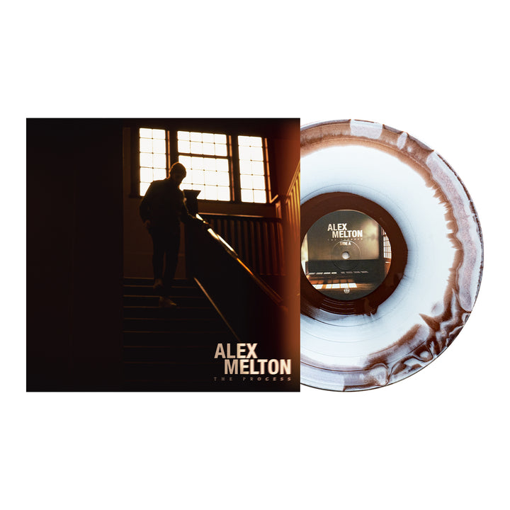 ALEX MELTON’s "THE PROCESS" album vinyl, with a white and brown marbled pattern, is shown beside its cover—a silhouette on stairs by a window. Available now for presale.