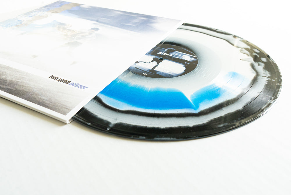A Wisher Blue Vinyl from Ben Quad, featuring a black, white, and blue splatter design, is shown partially out of its album cover with a blurred image and "ben mund wasser" text. Album presale available now.