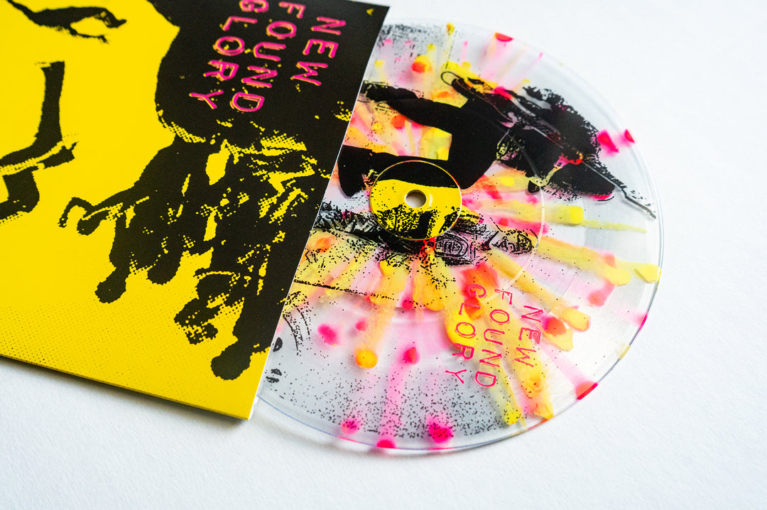 A vibrant New Found Glory vinyl LP with neon pink and yellow splatter peeks from a bright yellow cover, showcasing bold black and pink artwork. The bands name appears on both the album cover and the record.