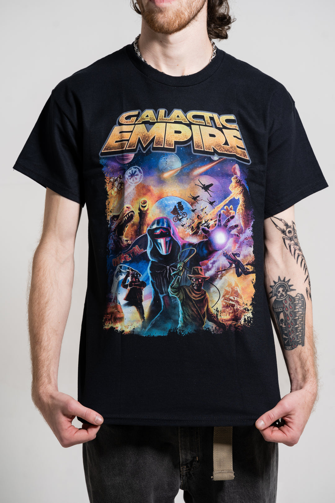 Someone wears a black Galactic Empire T-shirt with vibrant sci-fi artwork, featuring alien and robot characters in a dramatic cosmic scene and "Galactic Empire" text at the top.