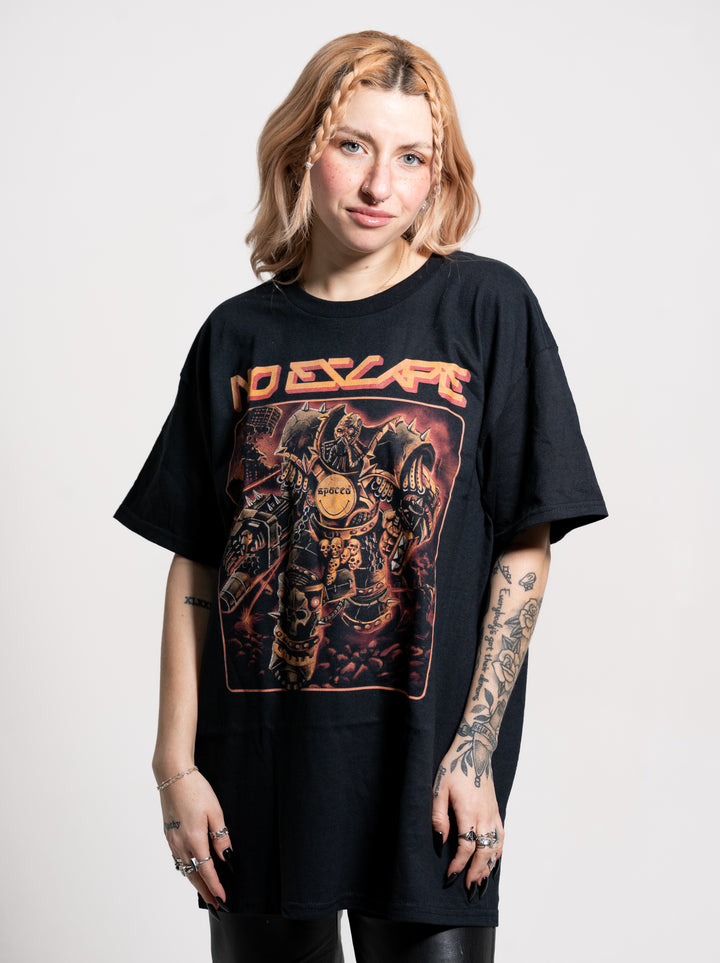 A woman with light brown hair and arm tattoos stands against a plain background, wearing a Spaced black oversized T-shirt featuring a colorful NO ESCAPE graphic and an armored figure on the front.