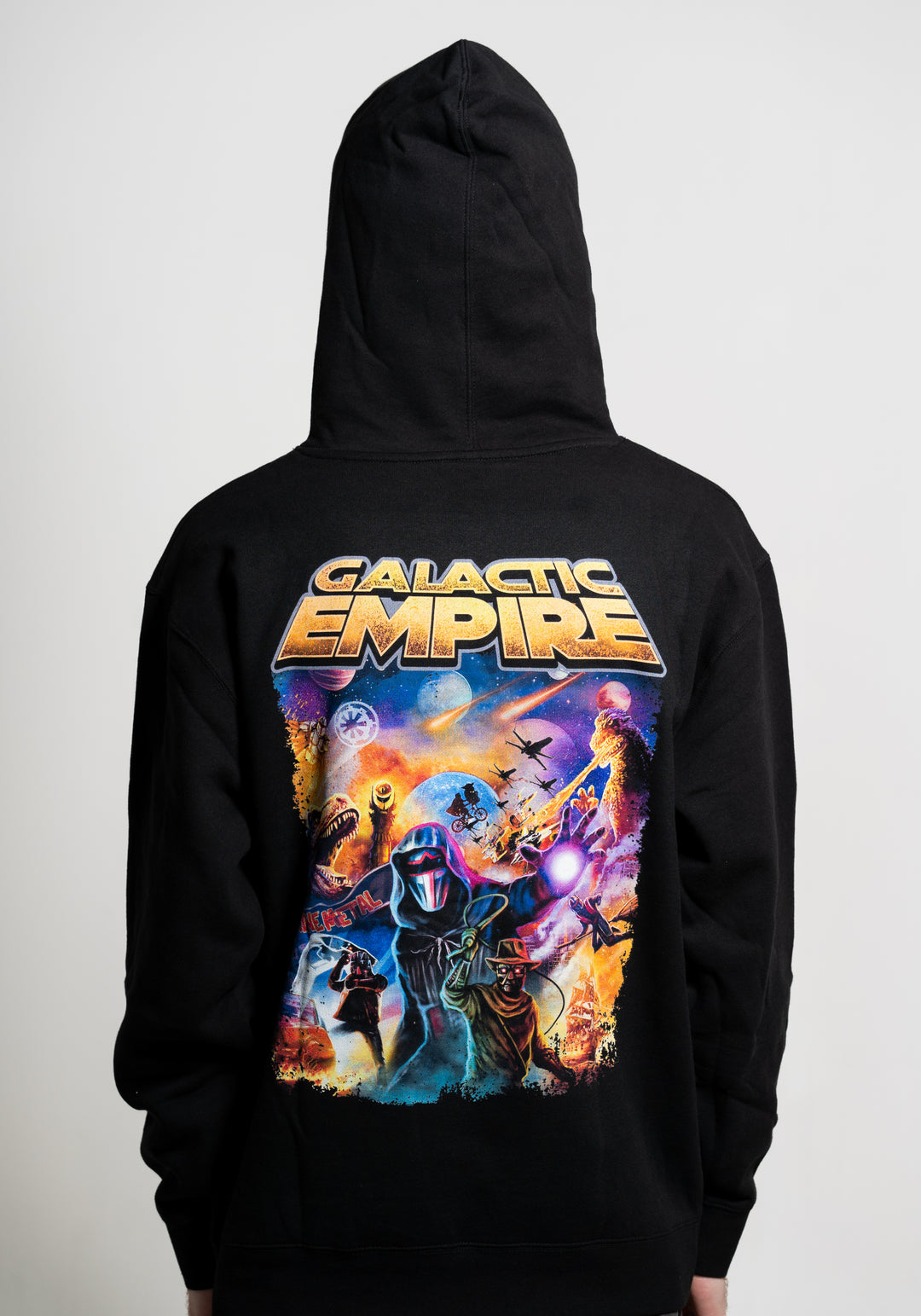 A person in a black Galactic Empire hoodie with the hood up; the back displays vibrant Galactic Empire text and colorful sci-fi artwork of spaceships, planets, and a masked figure with glowing eyes and a weapon.