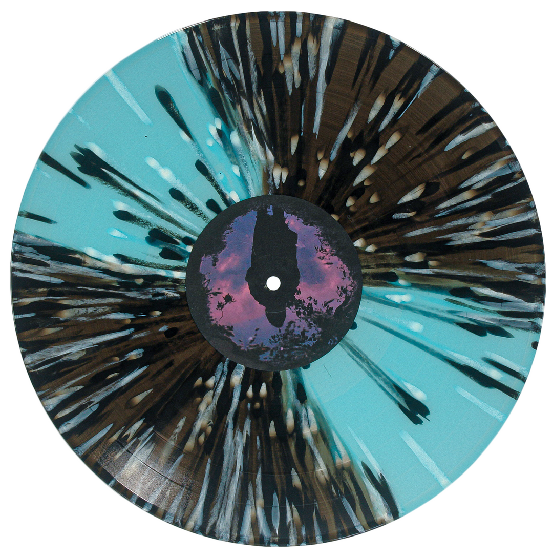 Vinyl record with artistic design and silhouette of a person against a sunset sky