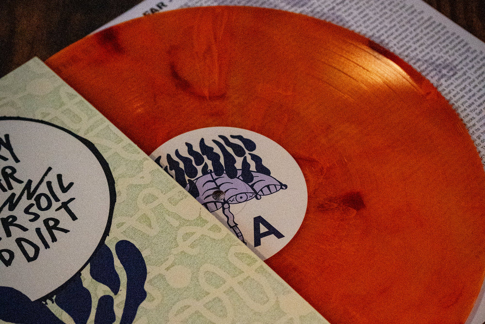 An orange Sunset Marble vinyl by The Story So Far partially slides out of its sleeve, displaying a white label with a black and purple abstract illustration. This 17th Press (limited to 1000) comes with the sleeve and a printed lyric sheet.