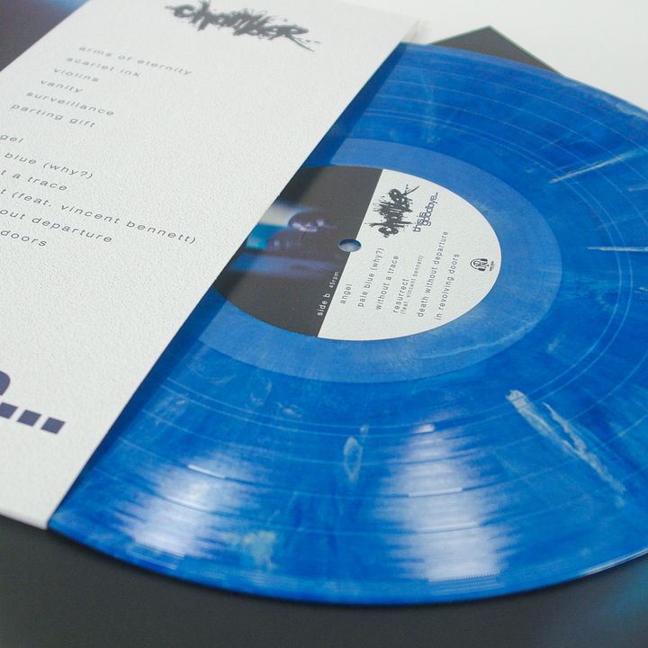 A metallic blue marble vinyl record partially inserted into a white paper sleeve with tracklist text.
